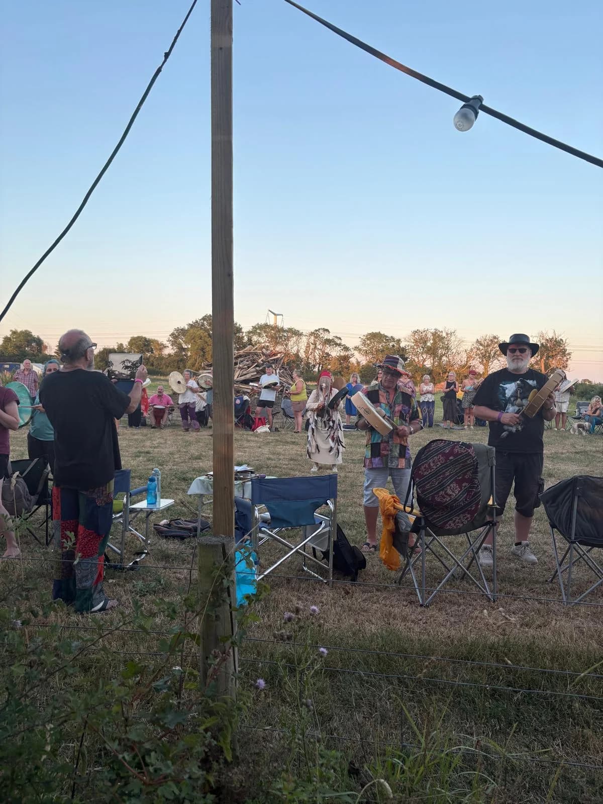 Campers sharing an evening drum circle beside their camping chairs